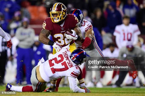 Running back Samaje Perine of the Washington Redskins is tackled by free safety Darian Thompson and defensive end Olivier Vernon of the New York...