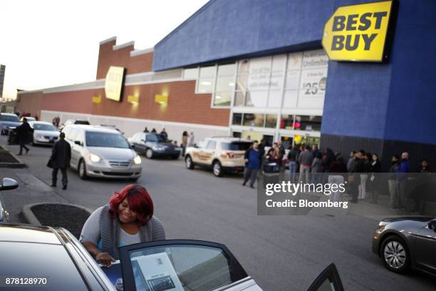 Shopper loads a Samsung Electronics Co. Television into her car outside a Best Buy Co. Store in Louisville, Kentucky, U.S., on Thursday, Nov. 23,...