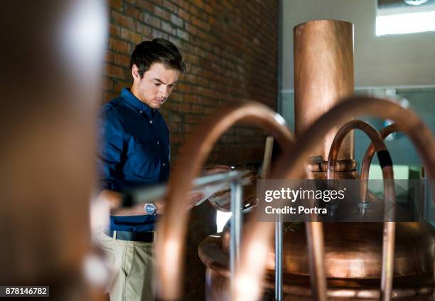 worker with tablet pc examining vat in brewery - distillery stock pictures, royalty-free photos & images