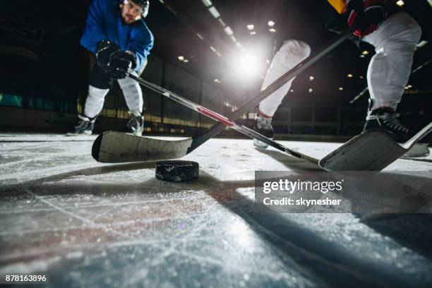nahaufnahme des eishockeypuck während eines spiels in eine eisbahn. - verteidiger eishockey stock-fotos und bilder