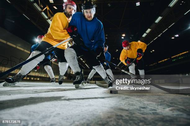 onder zicht op ice hockeyspelers die een wedstrijd in een ijsbaan. - verdediger ijshockey stockfoto's en -beelden