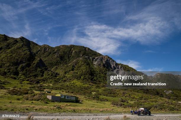 seaside bach with blue sky and thin lines of white clouds across sky, wairarapa, nz - bach new zealand imagens e fotografias de stock