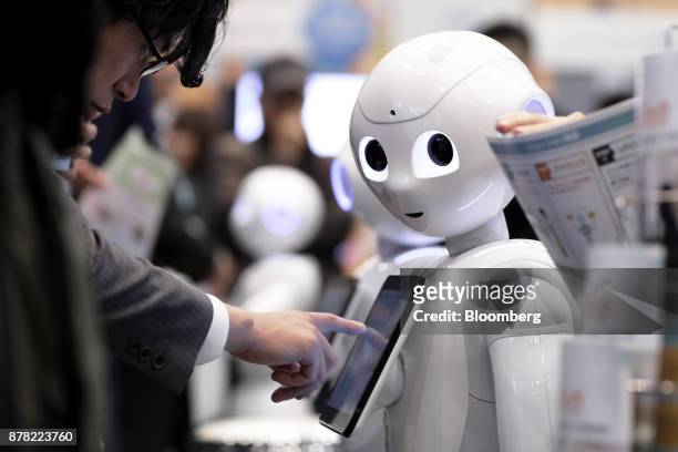 An attendee tries out an application on a SoftBank Group Corp. Pepper humanoid robot at the SoftBank Robot World 2017 in Tokyo, Japan, on Tuesday,...
