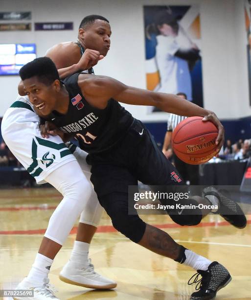 Malik Pope of the San Diego State Aztecs is fouled by Justin Strings of the Sacramento State Hornets as he drives to the basket in the first half of...