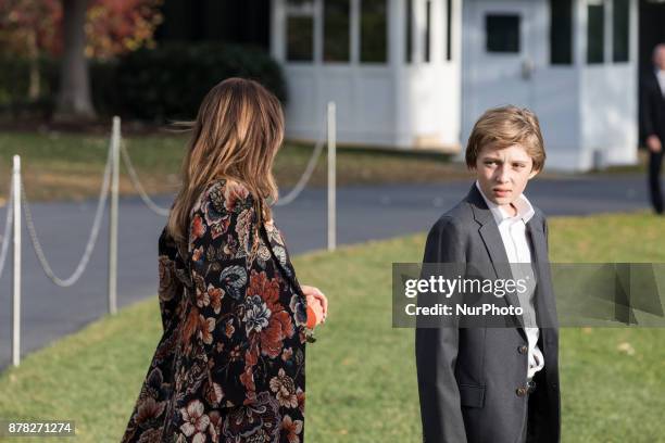 First Lady Melania Trump, and son Barron, wait for President Donald Trump as he speaks to reporters, before their departure for the Thanksgiving...