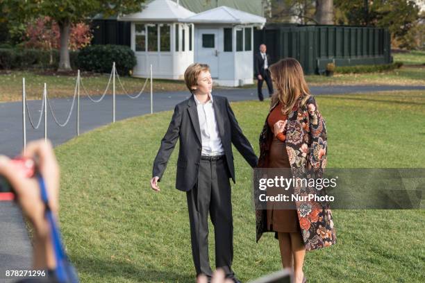 First Lady Melania Trump, and son Barron, wait for President Donald Trump as he speaks to reporters, before their departure for the Thanksgiving...