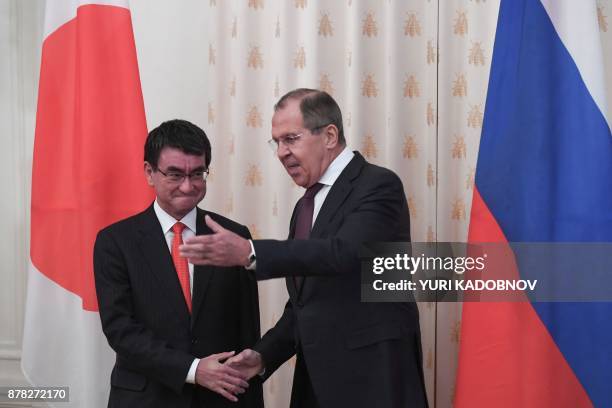 Russian Foreign Minister Sergei Lavrov shows the way his Japan's counterpart Taro Kono during a meeting in Moscow on November 24, 2017. / AFP PHOTO /...