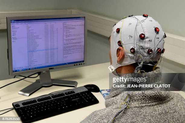 Picture taken on November 20, 2017 at the GIPSA-lab at the CNRS of Grenoble shows a researcher using a Brain-Computer-Interface helmet "Brain...