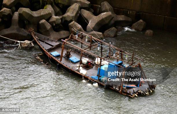 In this aerial image, a damaged wooden boat is seen at a marina on November 24, 2017 in Yurihonjo, Akita, Japan. Eight men found in the boat said...
