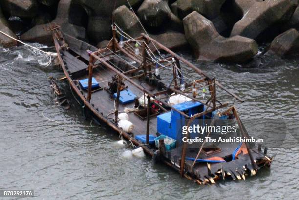 In this aerial image, a damaged wooden boat is seen at a marina on November 24, 2017 in Yurihonjo, Akita, Japan. Eight men found in the boat said...