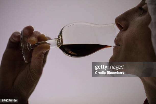 An employee samples a glass of Jaegermeister fruit liquor inside the laboratory at the Mast-Jaegermeister SE production site in Wolfenbuettel,...