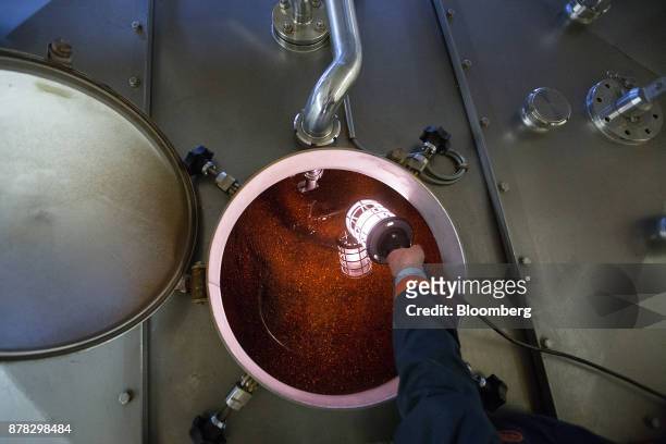 Torch illuminates herbs inside a maceration tank at the Mast-Jaegermeister SE fruit liquor production site in Wolfenbuettel, Germany, on Wednesday,...