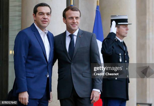 French President Emmanuel Macron welcomes Greek Prime Minister Alexis Tsipras prior to their meeting at the Elysee Presidential Palace on November...