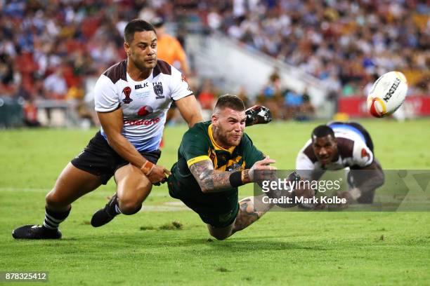 Josh Dugan of Australia passes as he is tackled by Jarryd Hayne of Fiji during the 2017 Rugby League World Cup Semi Final match between the...