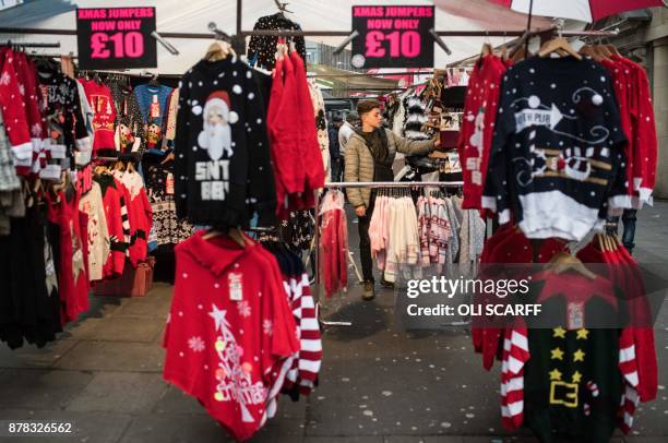 Christmas-themed jumpers are displayed for sale on a market stall in Nottingham city centre in Nottingham, central England on November 17, 2017....