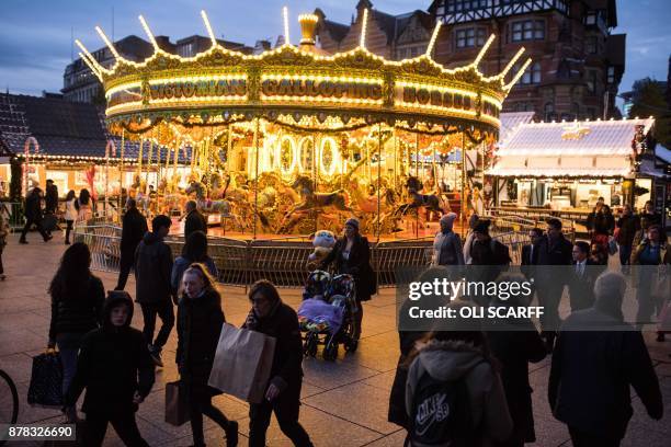 Members of the public make their way through a temporary seasonal Christmas market in Nottingham city centre in Nottingham, central England on...