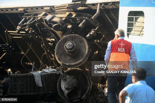 Indian rescue workers assess the derailed coaches of an Indian express train are pictured near Manikpur railway station in Uttar Pradesh on November...