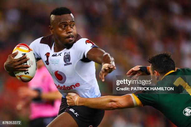 Akuila Uate of Fiji fends a tackle by Billy Slater of Australia during the Rugby League World Cup men's semi-final match between Australia and Fiji...