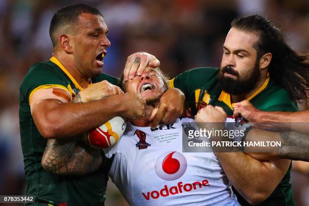 Ashton Sims of Fiji is tackled by Will Chambers and Aaron Woods of Australia during the Rugby League World Cup men's semi-final match between...
