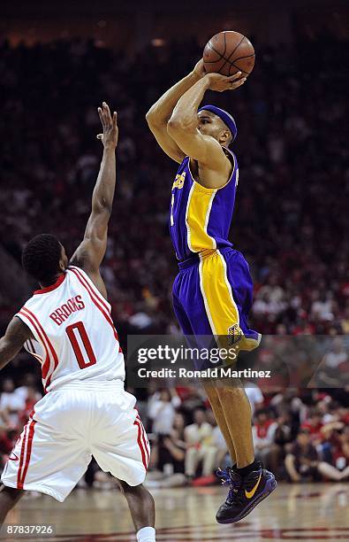 Guard Derek Fisher of the Los Angeles Lakers takes a shot against Aaron Brooks of the Houston Rockets in Game Six of the Western Conference...