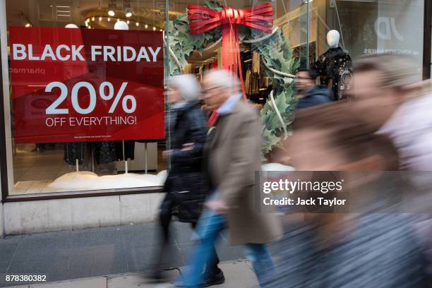 Shoppers walk past a Black Friday sale sign on Oxford Street on November 24, 2017 in London, England. British retailers offer deals on their products...