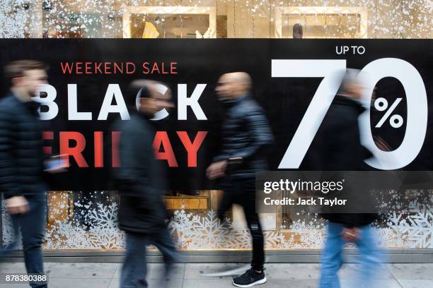 Shoppers walk past a Black Friday sale sign on Oxford Street on November 24, 2017 in London, England. British retailers offer deals on their products...