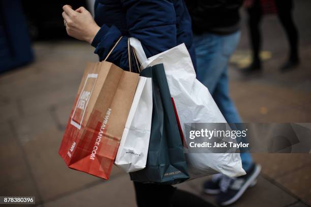 People carry shopping bags along Oxford Street on November 24, 2017 in London, England. British retailers offer deals on their products as part of...