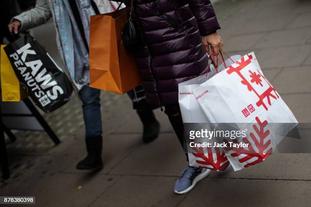 People carry shopping bags along Oxford Street on November 24, 2017 in London, England. British retailers offer deals on their products as part of...