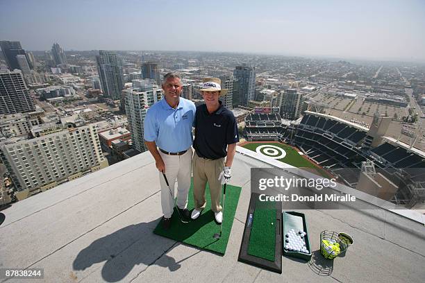 Player Briny Baird and Padres GM Kevin Towers pose for a photo before hitting off the roof of the Omni Hotel attempting to land a golf ball on a...