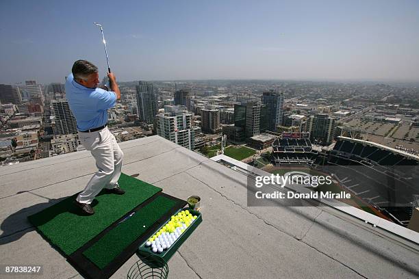 Padres GM Kevin Towers lands a practice swing off the roof of the Omni Hotel into a bulls-eye planted in right-center field at PETCO Park during the...