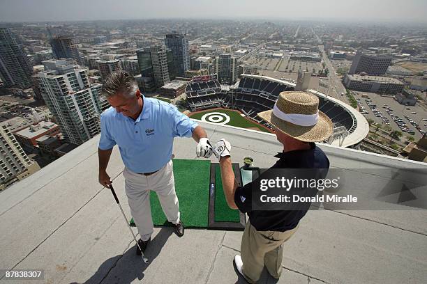 Padres GM Kevin Towers is congratulated by PGA TOUR Player Briny Baird after landing a practice swing off the roof of the Omni Hotel into a bulls-eye...