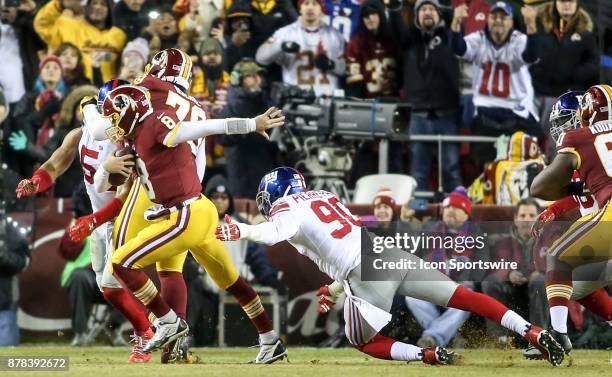 Washington Redskins quarterback Kirk Cousins sprints away from a tackle by New York Giants defensive end Jason Pierre-Paul during a NFL game between...