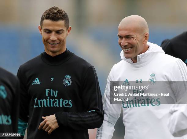 Cristiano Ronaldo and head coach Zinedine Zidane of Real Madrid smile during a training session at Valdebebas training ground on November 24, 2017 in...