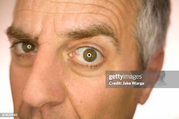 guy peering quizzically into lens - peer foto e immagini stock