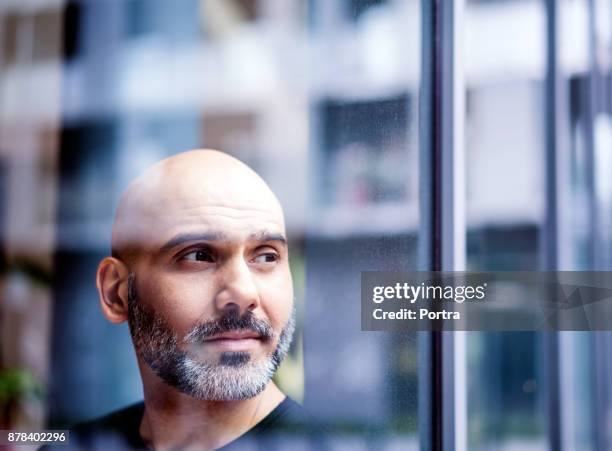 thoughtful businessman seen through window - hair loss stock pictures, royalty-free photos & images