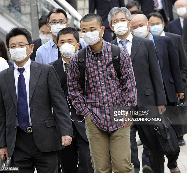 People wearing facemasks walk on their way to their offices in Kobe, Hyogo prefecture, in western Japan on May 19, 2009. Japan closed more than 4,000...