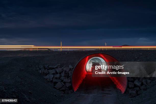 suv driving through small tunnel, iceland - red car stock pictures, royalty-free photos & images