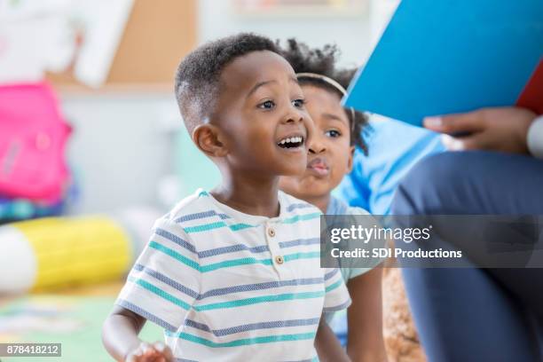 excited preschool boy enjoying story time - kids reading in classroom stock pictures, royalty-free photos & images