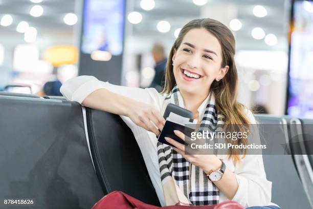 young woman waits for international flight at airport - transcontinental railroad stock pictures, royalty-free photos & images