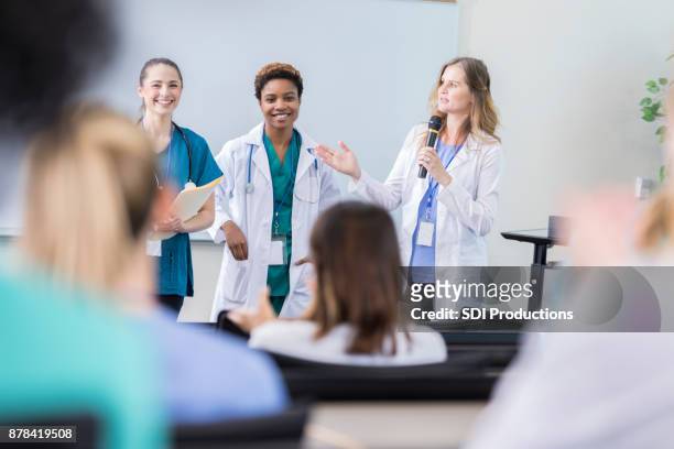 自信を持って女性医師医療セミナーで聴衆に対処します。 - public address ストックフォトと画像