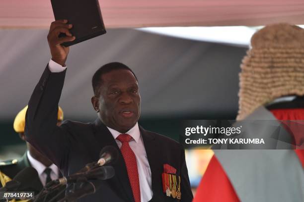 Zimbabwe's new interim President Emmerson Mnangagwa takes the oath of office before Chief judge of the Supreme Court Luke Malaba as he is officially...