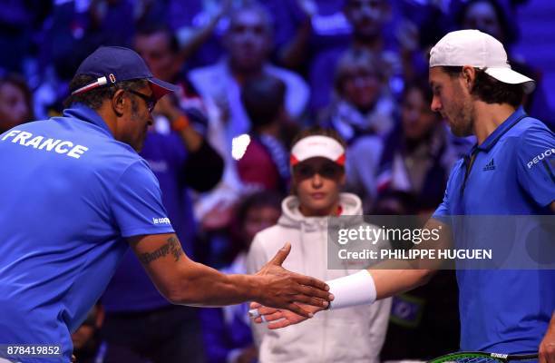 France's Lucas Pouille shakes hands with captain Yannick Noah after winning a point during the Davis Cup World Group singles rubber final tennis...