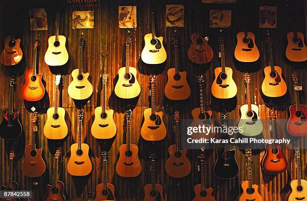 acoustic guitars on a wall - acoustic guitar foto e immagini stock