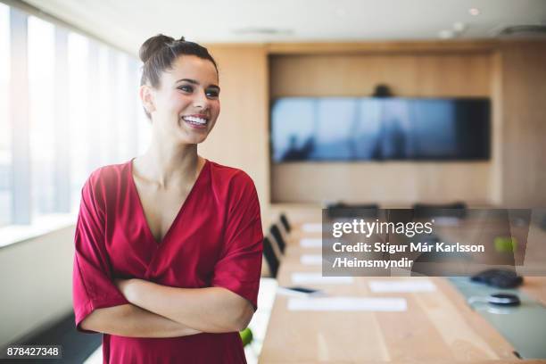 empresária sorridente em pé com os braços cruzados  - mesa de reunião - fotografias e filmes do acervo