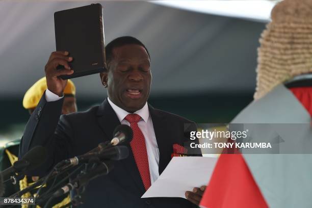 Zimbabwean new interim President Emmerson Mnangagwa takes the oath of office before Chief judge of the Supreme Court, Luke Malaba as he is officially...