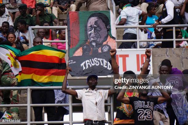 Supporters hold a portrait of Zimbabwes new President Emmerson Mnangagwa during his inauguration on November 24, 2017 in Harare. Emmerson Mnangagwa...