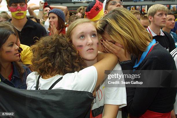 German soccer fans react to a missed goal in the World Cup soccer finals against Brazil while watching the game on a large screen TV June 30, 2002 in...