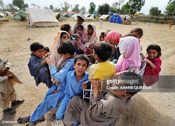 Pakistani internally displaced young girls, fleeing from military operations against Taliban militants in troubled Swat valley and Buner, play at a...