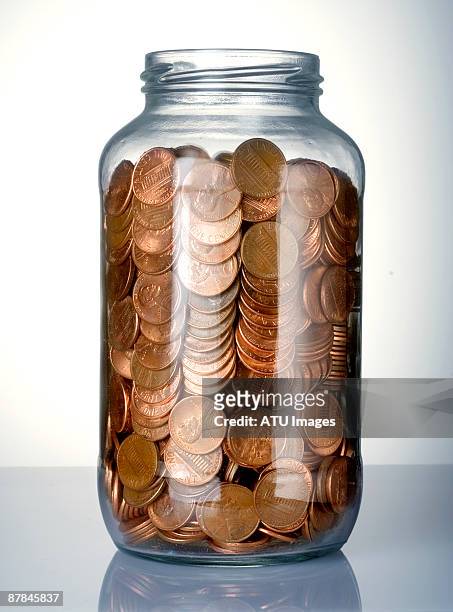 pennies in jar - coin photos fotografías e imágenes de stock
