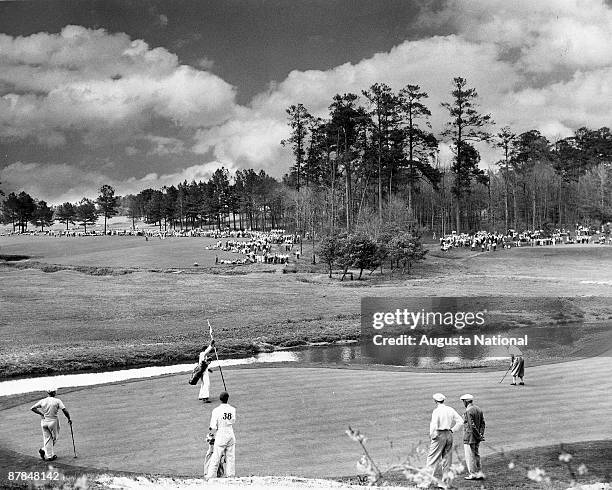 Bobby Locke, of South Africa, putts up the rise on the 12th green while playing Jimmy Demaret, left, and Sam Snead during the 1948 Masters Tournament...